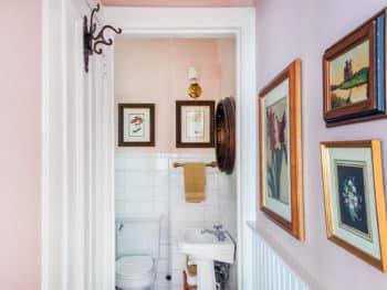 Bathroom with white tiling, pedestal sink and toilet