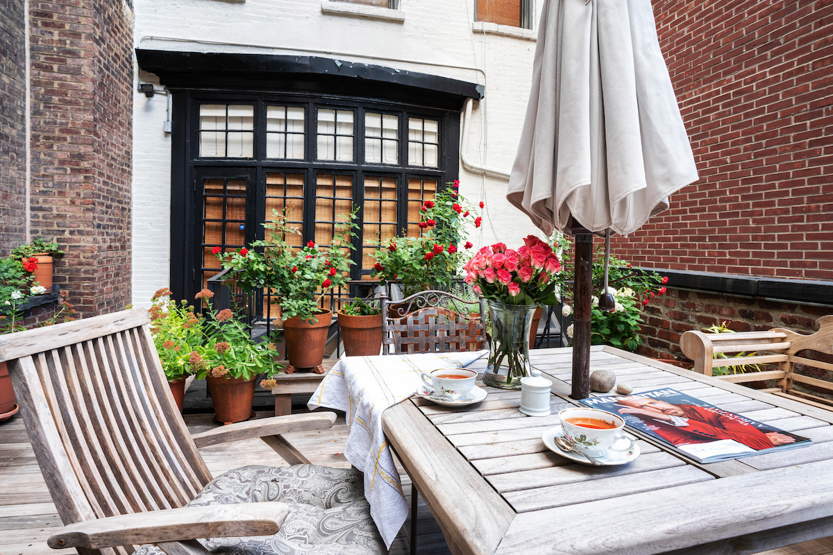 Terrace with square teak table, large umbrella and plants