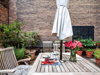 Terrace with square teak table, large umbrella and plants