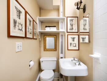 Bathroom with many prints. White pedestal sink