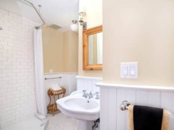 bathroom with white pedestal sink and beige walls.