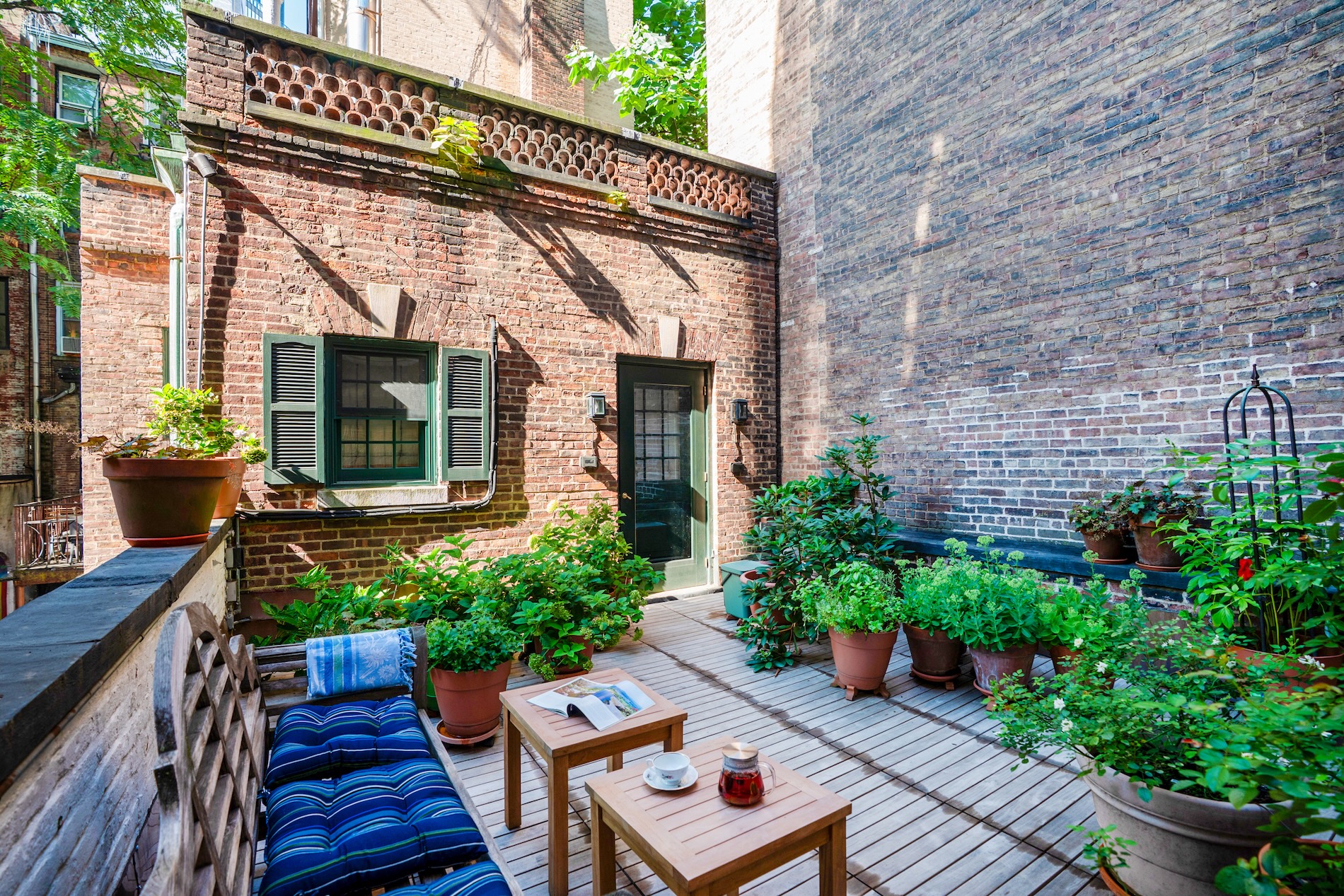 Carriage House with a deck, planters and 2 side tables