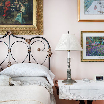 Beige-painted bedroom with sleigh bed, dresser next to bed and red rug